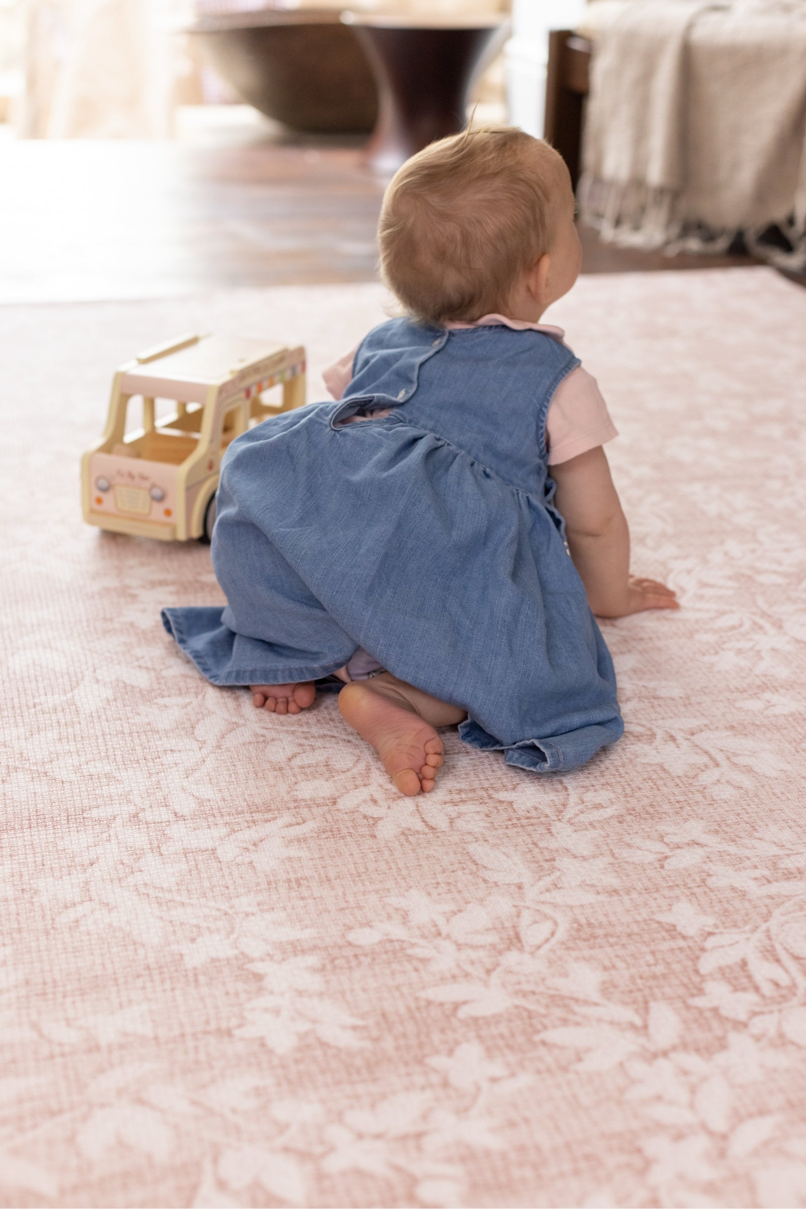 Baby crawling on a floral pink aster play mat from totter and tumble