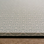 A close-up of the Beachcomber play mat  with a repeating geometric shell pattern, resting on a wooden surface. | SKU: 26 BEACH/GATHER XL, 26 BEACH/GATHER STD, 26 BEACH/GATHER COMP