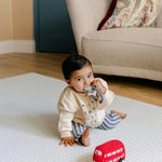 A baby sat playing on the beachcomber play mat from totter and tumble | SKU: 26 BEACH/GATHER XL, 26 BEACH/GATHER STD, 26 BEACH/GATHER COMP