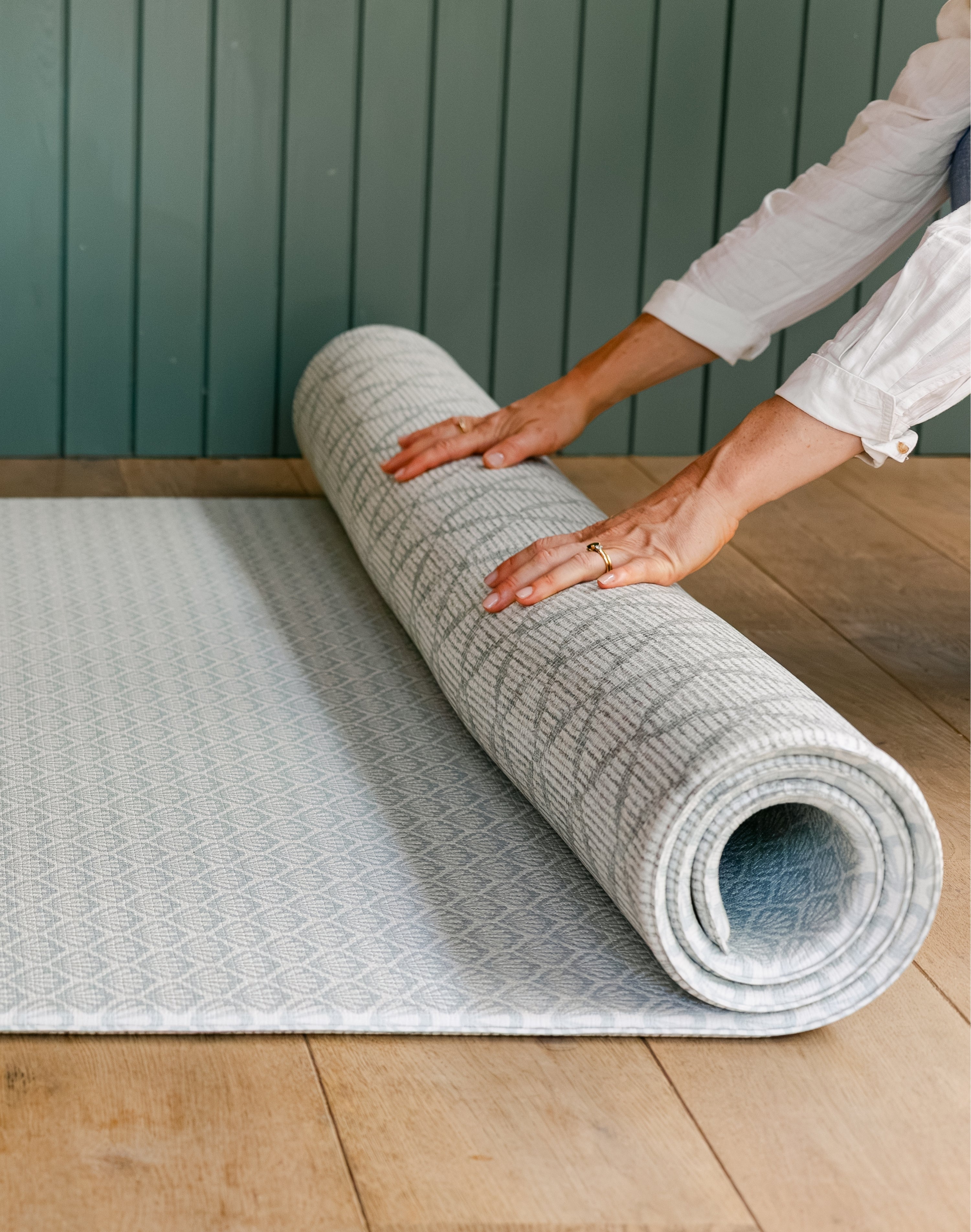 A person unrolling The Beachcomber play mat showing it's reversible design | SKU: 26 BEACH/GATHER XL, 26 BEACH/GATHER STD, 26 BEACH/GATHER COMP