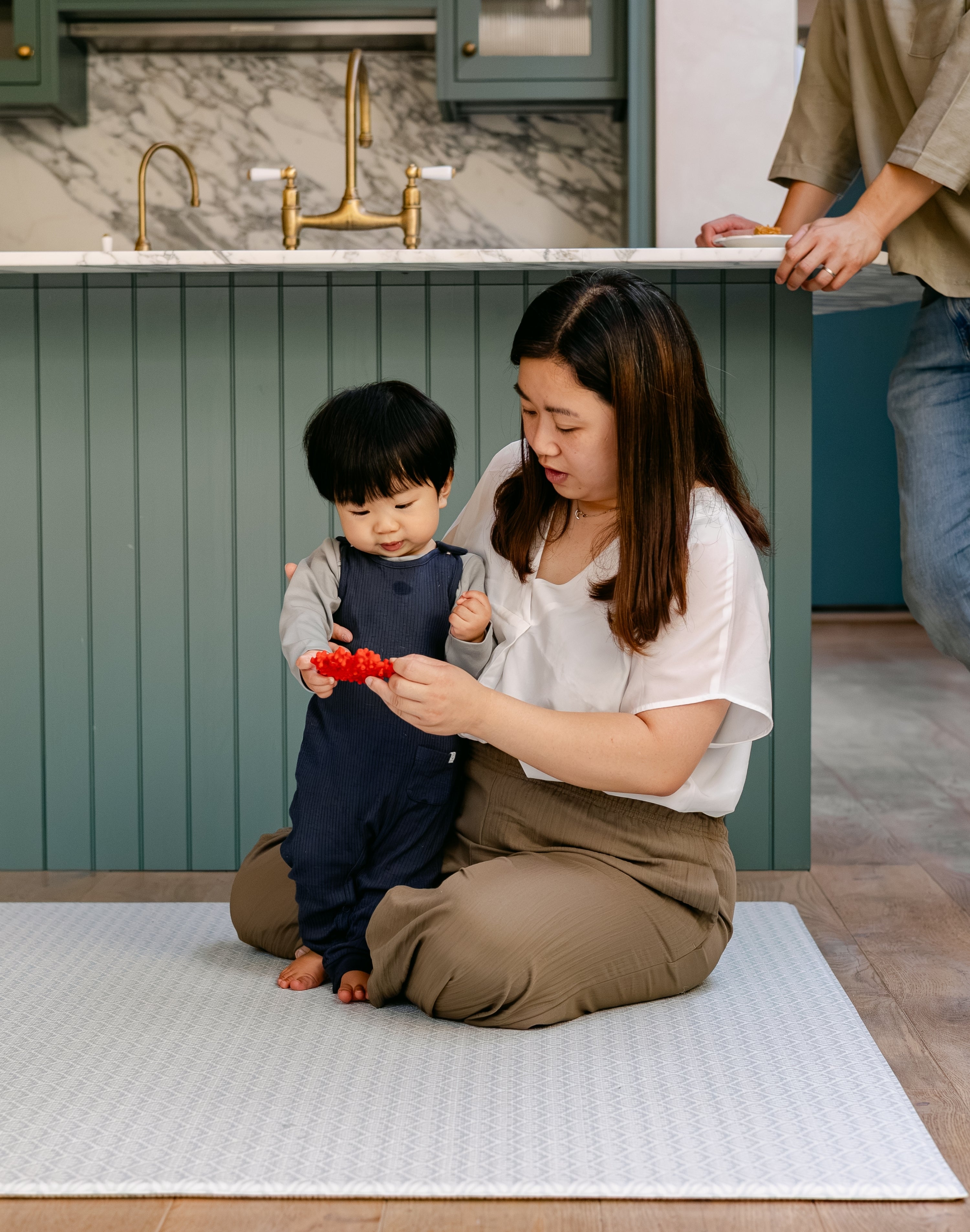 A family sat comfortably on the beachcomber play mat in a kitchen diner | SKU: 26 BEACH/GATHER XL, 26 BEACH/GATHER STD, 26 BEACH/GATHER COMP