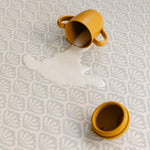 Close up of spilt milk on The Beachcomber rug-like play mat from totter and tumble. Easy to clean, safe and non toxic. | SKU: 26 BEACH/GATHER XL, 26 BEACH/GATHER STD, 26 BEACH/GATHER COMP