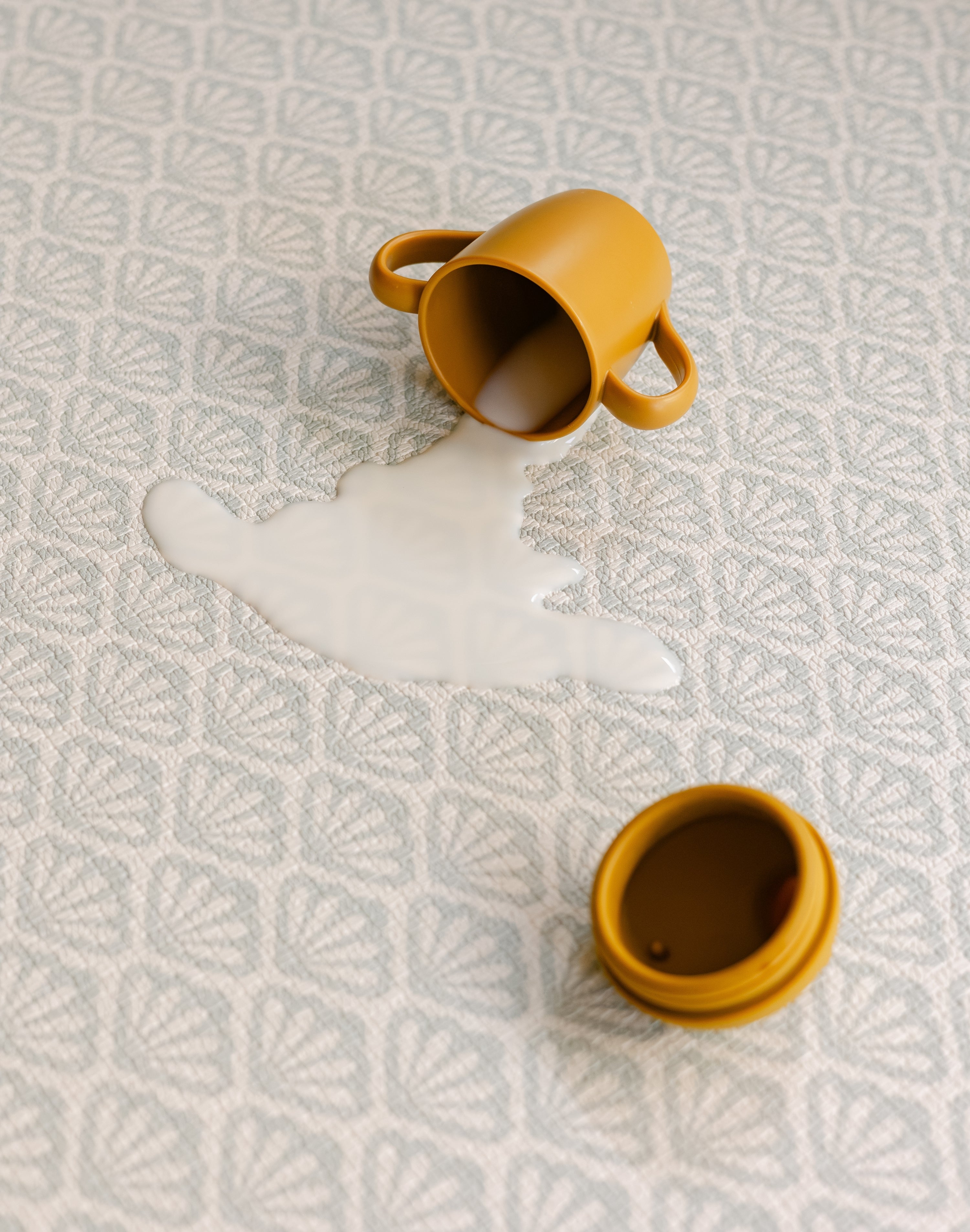 Close up of spilt milk on The Beachcomber rug-like play mat from totter and tumble. Easy to clean, safe and non toxic. | SKU: 26 BEACH/GATHER XL, 26 BEACH/GATHER STD, 26 BEACH/GATHER COMP