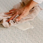 Spilt milk being easily cleaned up on The Beachcomber rug-like, soft, safe, memory foam play mat from totter and tumble | SKU: 26 BEACH/GATHER XL, 26 BEACH/GATHER STD, 26 BEACH/GATHER COMP