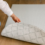 A person showing both sides of the reversible coastal inspired beachcomber play mat | SKU: 26 BEACH/GATHER XL, 26 BEACH/GATHER STD, 26 BEACH/GATHER COMP