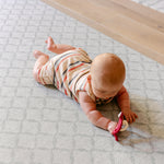 A baby enjoying tummy time safely and comfortably on the gatherer rug-like play mat from totter and tumble | SKU: 26 BEACH/GATHER XL, 26 BEACH/GATHER STD, 26 BEACH/GATHER COMP