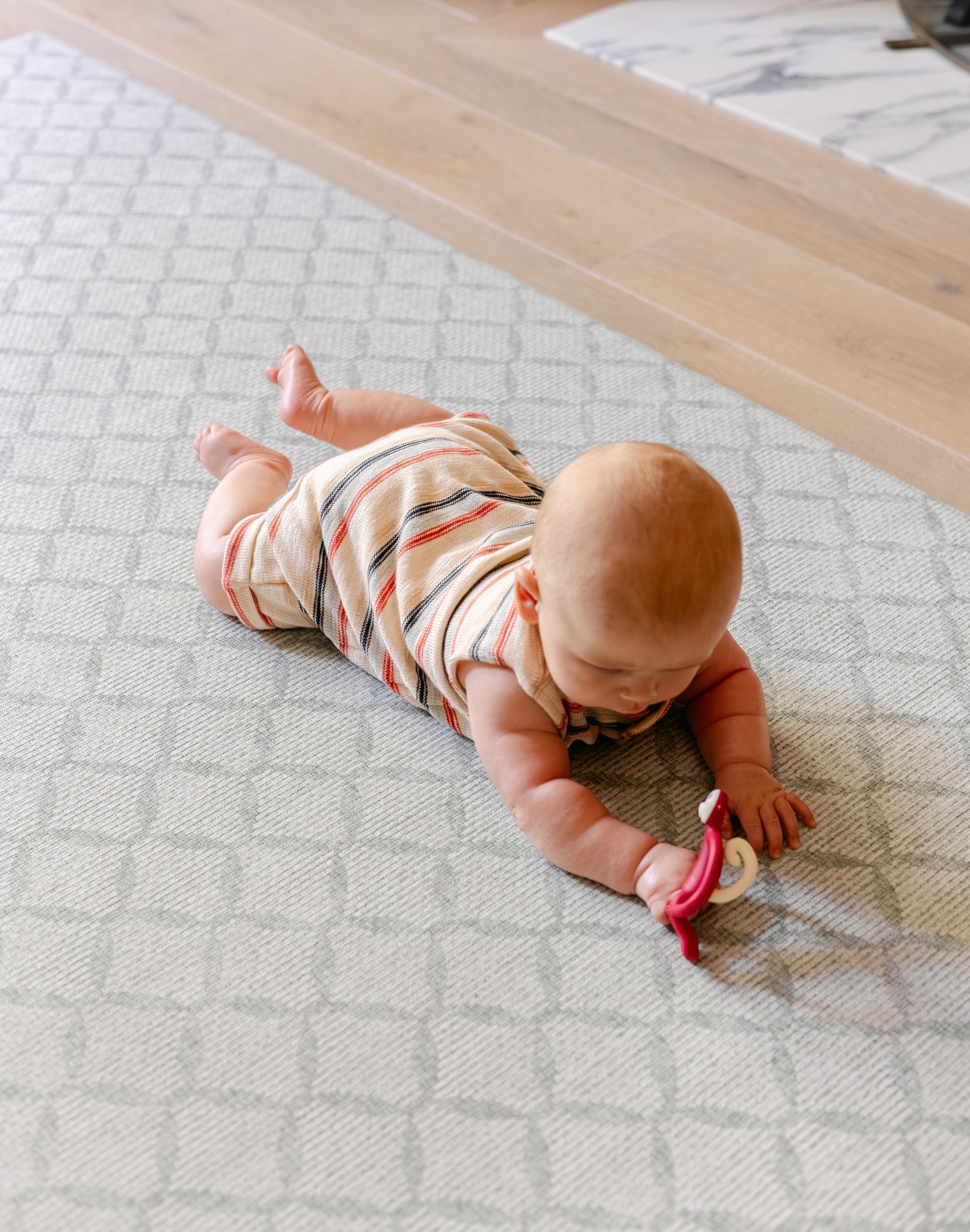 A baby enjoying tummy time safely and comfortably on the gatherer rug-like play mat from totter and tumble | SKU: 26 BEACH/GATHER XL, 26 BEACH/GATHER STD, 26 BEACH/GATHER COMP