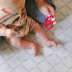 A baby sat comfortably on a coastal inspired design play mat from totter and tumble | SKU: 26 BEACH/GATHER XL, 26 BEACH/GATHER STD, 26 BEACH/GATHER COMP