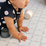 A baby pressing their hands on a thick soft safe memory foam play mat from totter and tumble | SKU: 26 BEACH/GATHER XL, 26 BEACH/GATHER STD, 26 BEACH/GATHER COMP