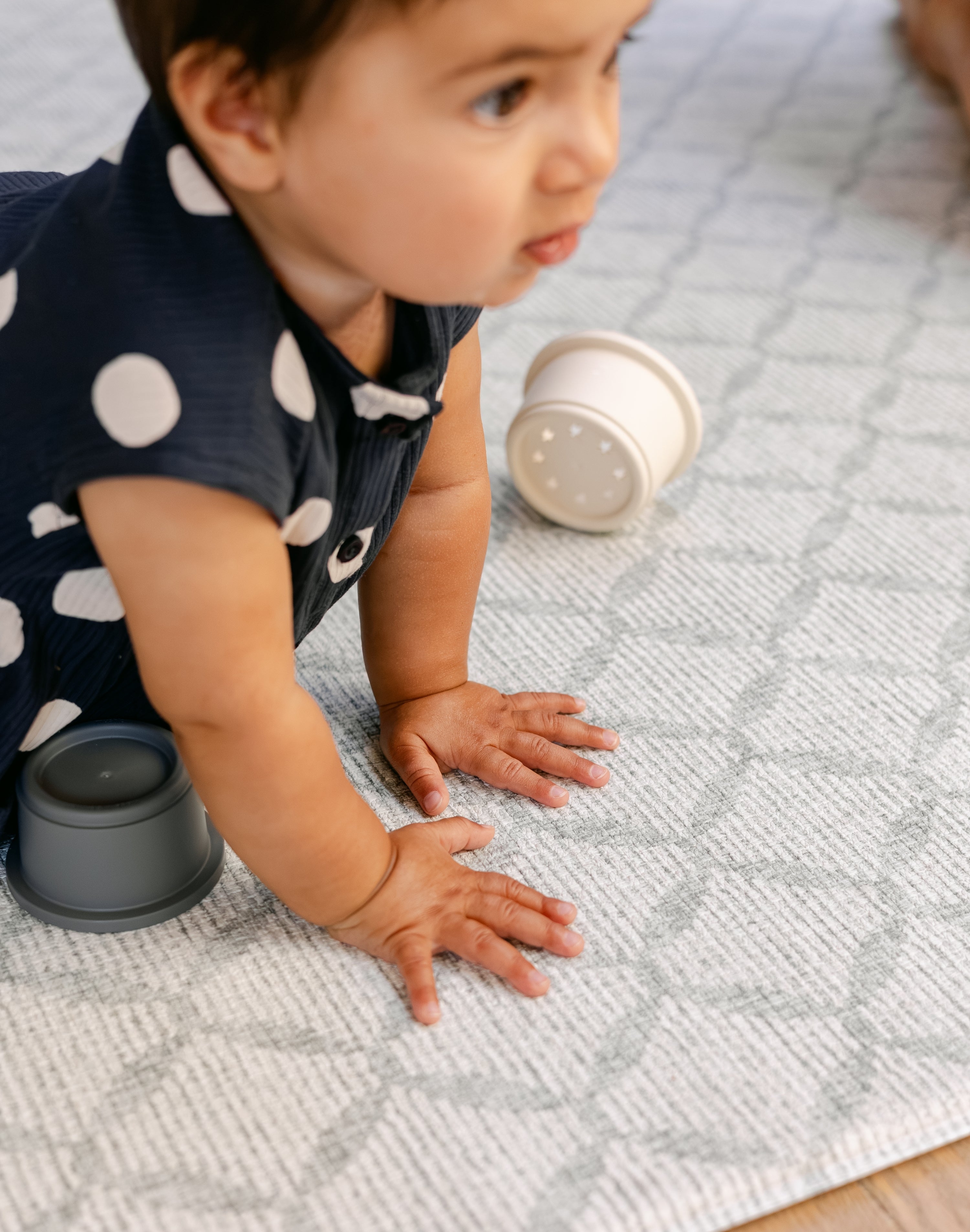 A baby pressing their hands on a thick soft safe memory foam play mat from totter and tumble | SKU: 26 BEACH/GATHER XL, 26 BEACH/GATHER STD, 26 BEACH/GATHER COMP