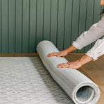 A woman unrolling a reversible non toxic rug-like play mat | SKU: 26 BEACH/GATHER XL, 26 BEACH/GATHER STD, 26 BEACH/GATHER COMP