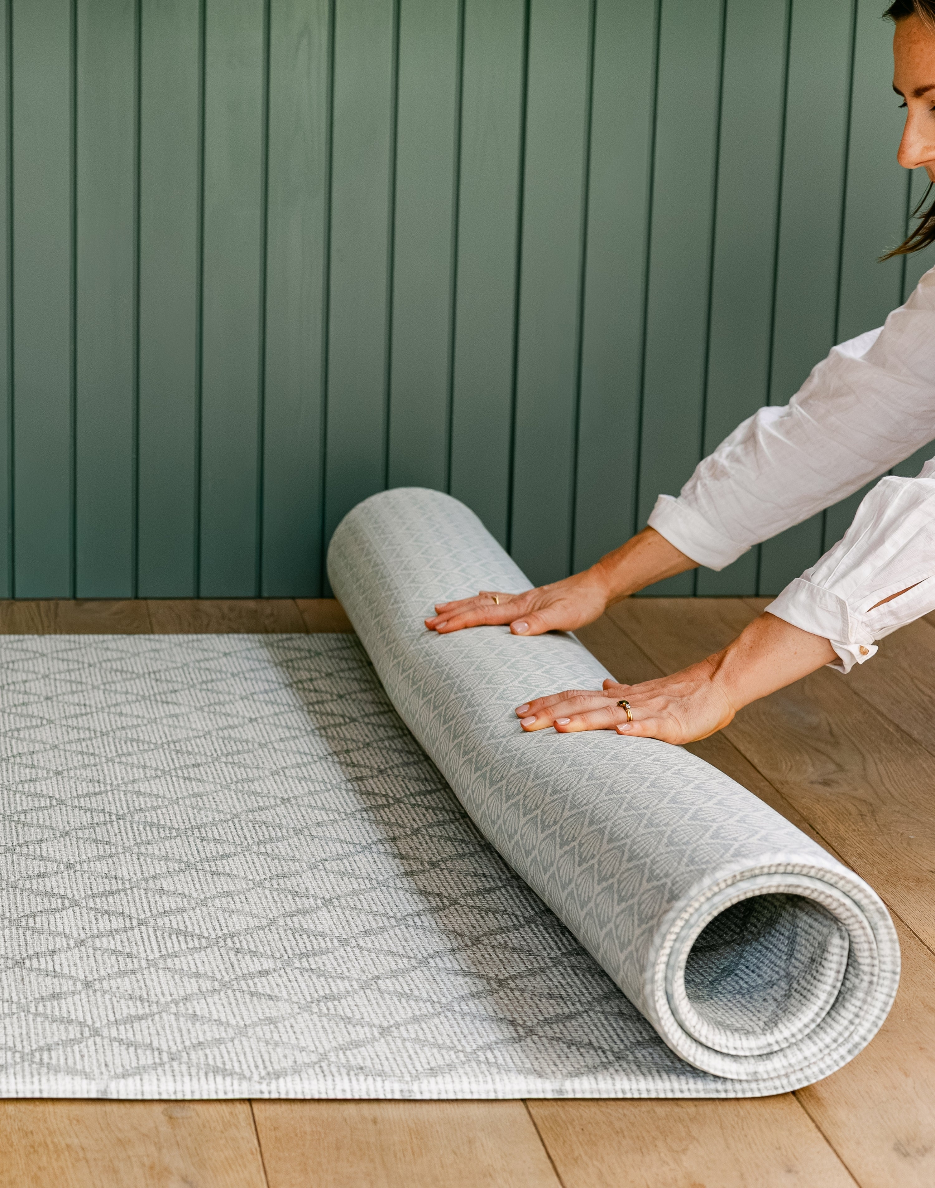 A woman unrolling a reversible non toxic rug-like play mat | SKU: 26 BEACH/GATHER XL, 26 BEACH/GATHER STD, 26 BEACH/GATHER COMP