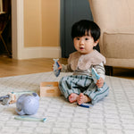 A baby sat comfortably, playing on a rug-like The Gatherer play mat from totter and tumble | SKU: 26 BEACH/GATHER XL, 26 BEACH/GATHER STD, 26 BEACH/GATHER COMP