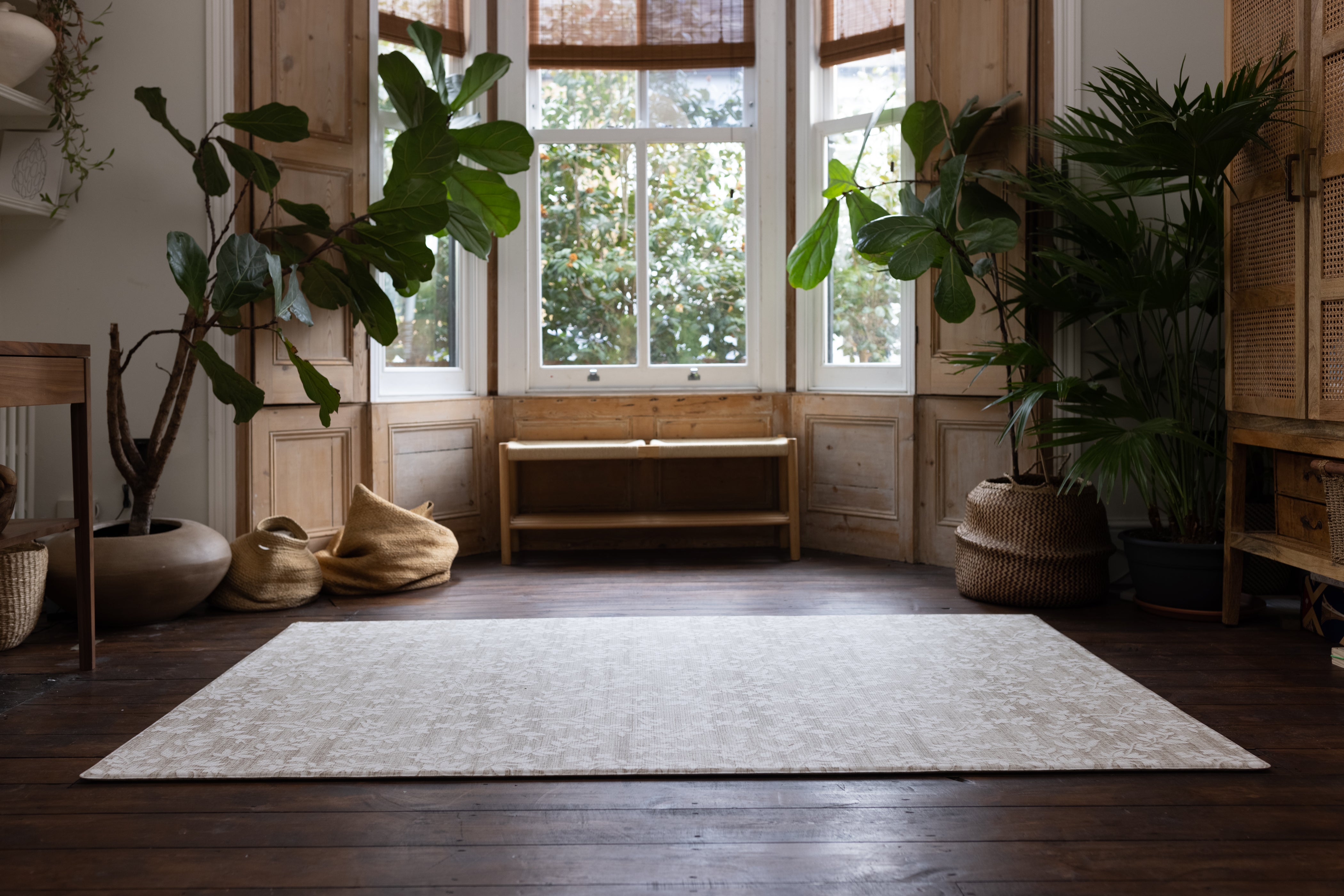 large rug-like floral play mat in neutral shades on a living room floor