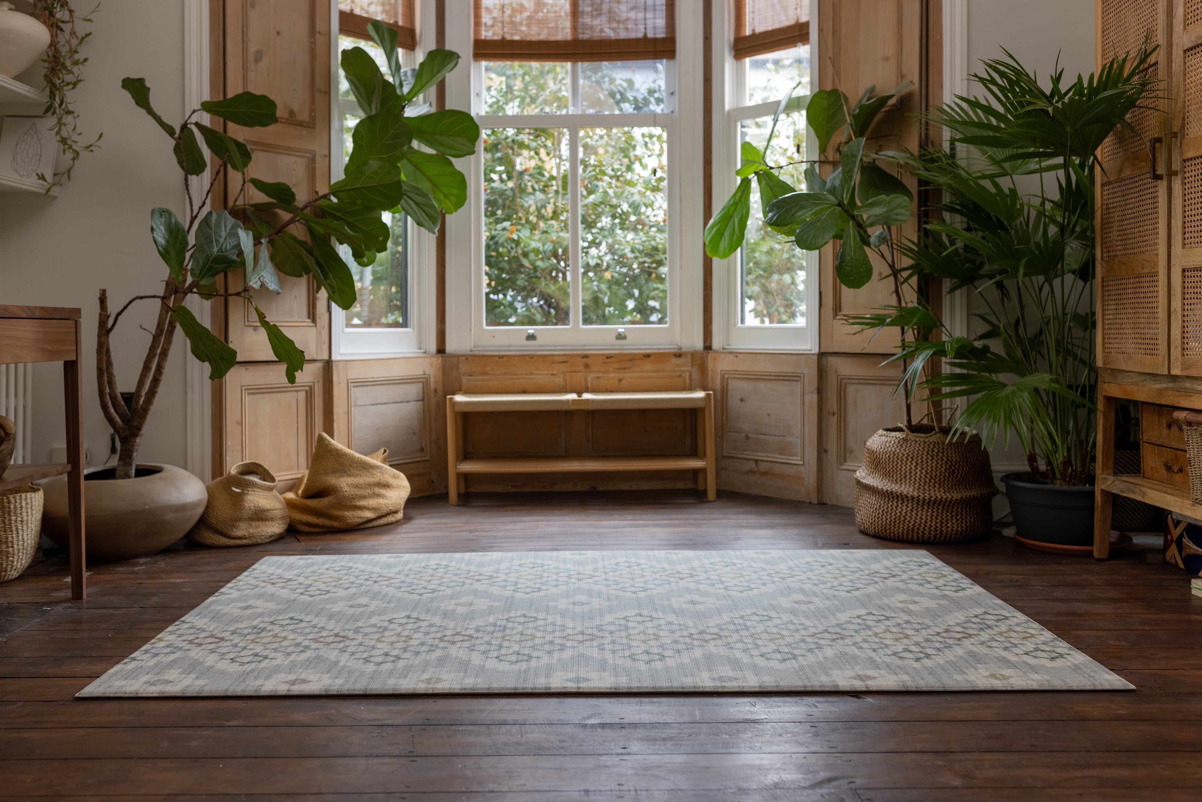 large rug-like geometric play mat in shades of blue on a living room floor